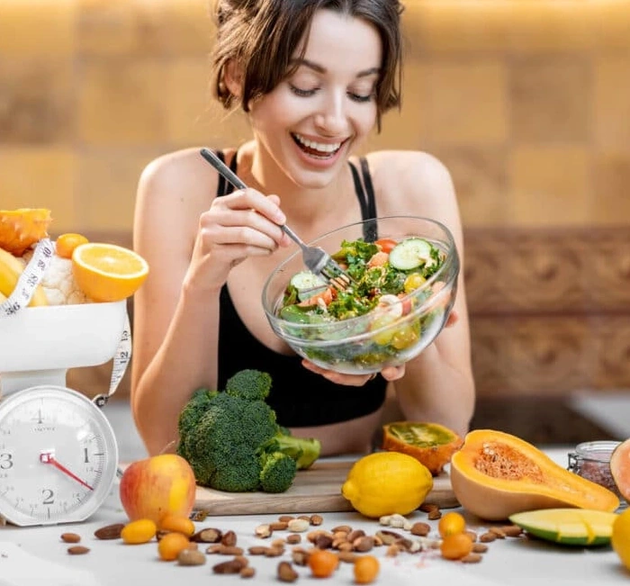 A plate of salad beside a set of kitchen scales
